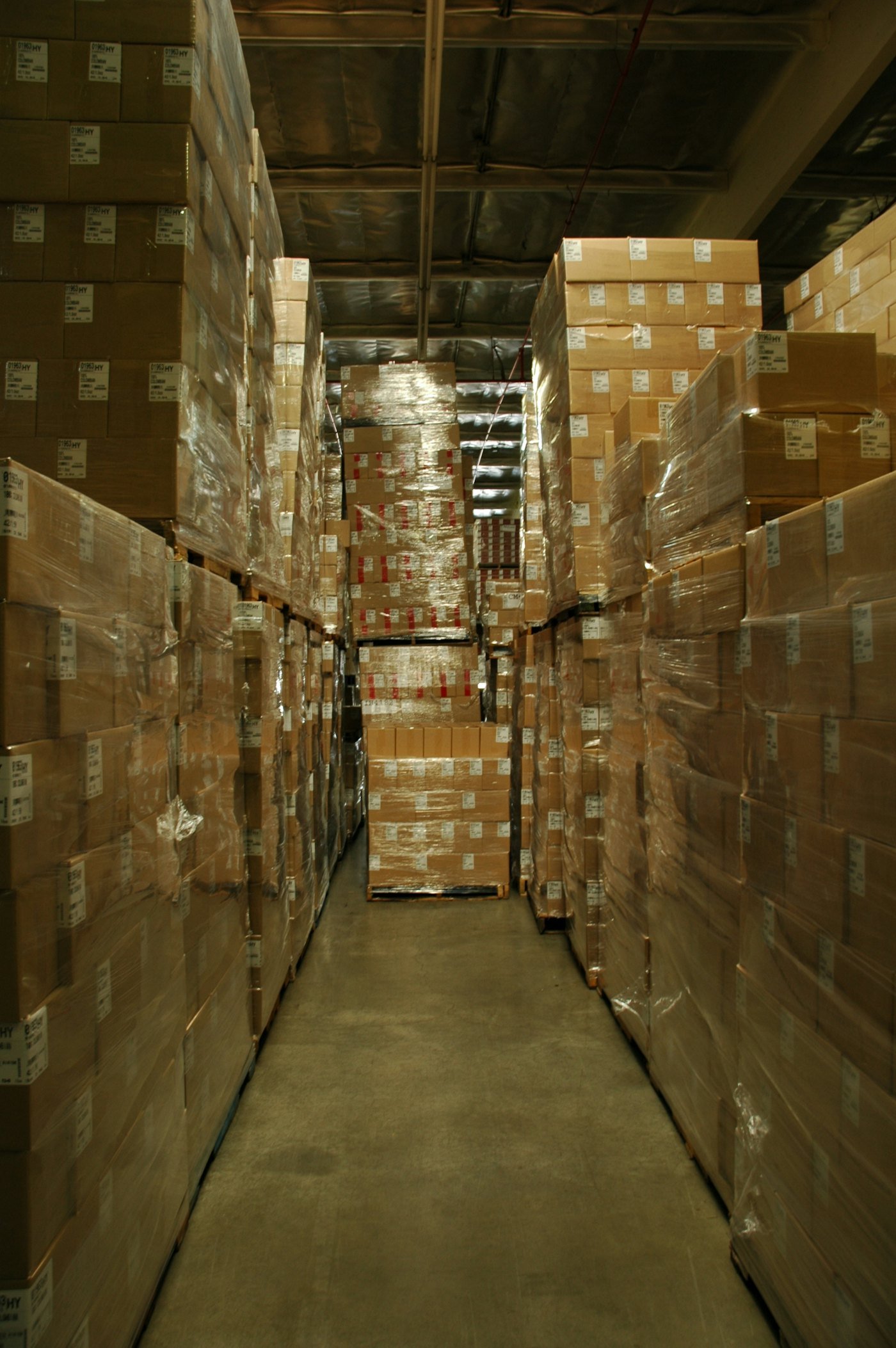 An aisle of wrapped pallets in the warehouse